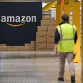 A US giant Amazon employee passes by its logo on the opening day of the new distribution center in Augny, eastern France, on September 23, 2021. (Photo by SEBASTIEN BOZON/AFP via Getty Images)