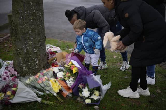 Flowers are left near the scene after three young boys died when a number of children fell through ice on a lake in Solihull.