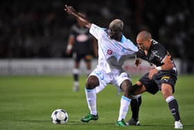 (FILES) In this file photo taken on September 13, 2008 Girondin’s forward Yoan Gouffran (R) fights for the ball with with Marseille’s Cameroonian midfielder Modeste M’ Bami during the French L1 football match between Bordeaux and Olympique de Marseille, at the Chaban Delmas stadium in Bordeaux, southwestern France. - Cameroonian Modeste M’Bami, former midfielder for Paris Saint-Germain and Olympique de Marseille died aged 40 in Le Havre, announces sports agent Frank Belhassen, on January 7, 2023. (Photo by PIERRE ANDRIEU / AFP) (Photo by PIERRE ANDRIEU/AFP via Getty Images)