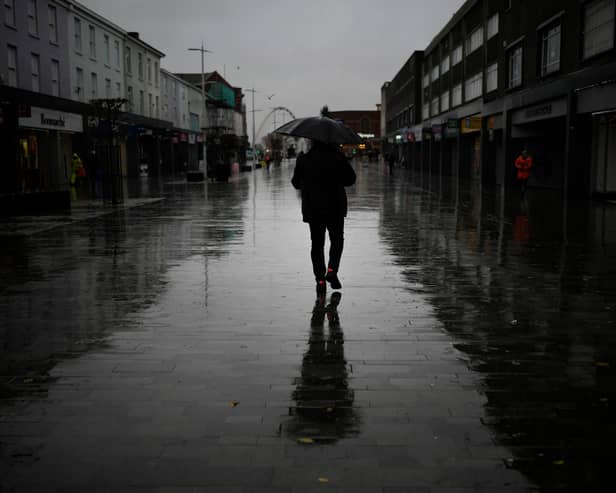 Dismal weather heralds the arrival of the UK Chancellor’s Autumn Statement as people shop in the centre of Bolton.