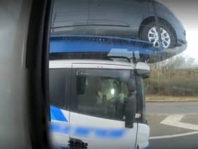 Footage shows the driver using his elbow to control the car transporter (Photo: Highways England) 