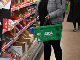 A shopper wearing a protective face covering to combat the spread of the coronavirus, chooses items off the shelves of an Asda supermarket in London on December 14, 2020. - With just over two weeks to go until Britain leaves the EU single market, preparations have been stepped up as fears grow about the impact of customs checks and congested ports. Concern is rising over the supply of perishable fresh fruit and vegetables, much of which is imported from EU countries. (Photo by Daniel LEAL / AFP) (Photo by DANIEL LEAL/AFP via Getty Images)