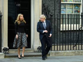 Prime Minister Boris Johnson and his partner Carrie Symonds stand outside the door of number 10 Downing Street (Photo by Leon Neal/Getty Images)