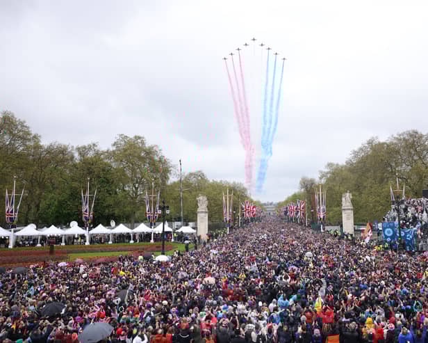 Crowds made their way down the Mall and towards Buckingham Palace, to greet to the new King and Queen at the balcony of Buckingham Palace. Shortly after the royal arrival on the balcony, a traditional Red Arrow flyover - which had been scaled back due to weather - brightened the rainy skies over London. (Credit: Getty Images)