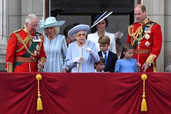 Britain's Queen Elizabeth II (C) stands with from left, Britain's Prince Charles, Prince of Wales, Britain's Prince Louis of Cambridge, Britain's Catherine, Duchess of Cambridge, Britain's Prince George of Cambridge, Britain's Princess Charlotte of Cambridge, and Britain's Prince William, Duke of Cambridge, to watch a special flypast from Buckingham Palace balcony following the Queen's Birthday Parade, the Trooping the Colour, as part of Queen Elizabeth II's platinum jubilee celebrations, in London on June 2, 2022.  (Photo by DANIEL LEAL/AFP via Getty Images)