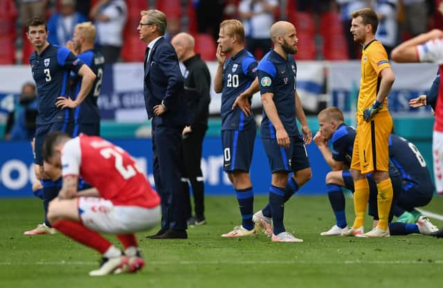 Markku Kanerva, Head Coach of Finland and Teemu Pukki of Finland wait on the pitch as Christian Eriksen (Not pictured) of Denmark receives medical treatment during the UEFA Euro 2020 Championship Group B match between Denmark and Finland on June 12, 2021 in Copenhagen, Denmark. (Photo by Stuart Franklin/Getty Images)