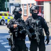 Armed police on Ilkeston Road, Nottingham, which is cordoned off after two people were found dead in the street.