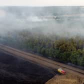 In this aerial view, a fire engine is seen on the field while smoke rises from the trees on July 19, 2022 in Blidworth, England