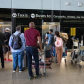 People queue for a lift at Heathrow Airport.