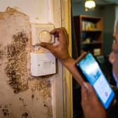 Doreen Thompson adjusts her thermostat at her home as she limits her use of heating to keep up with her increasing energy bills, at her home in south London.