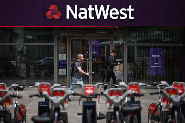 Pedestrians walk past a branch of a NatWest bank in London.