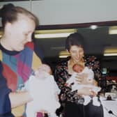 Bronwyn is held by mum Debbie as a baby, and Jack is held by mum Sharon.