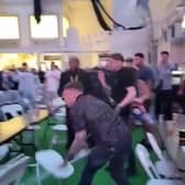 Men can be seen throwing chairs across the room at the Winter Gardens first Euros Fanzone match. 