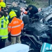 Footage of the aftermath of a car crash that left two pedestrians hospitalised shows a man being pulled from the wreckage.  