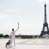 Torch bearer Matthias Dandois, French bicycle rider, poses for a photo with the Olympic Torch with the Eiffel Tower in view (Photo: Maja Hitij/Getty Images)