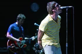 Liam (R) and Noel Gallagher perform on stage. Photo: JOSE JORDAN/AFP via Getty Images