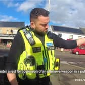 Police officer pulls huge machete from dealer's coat.