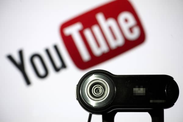 File photo of a camera positioned in front of YouTube's logo. Photo: LIONEL BONAVENTURE/AFP via Getty Images