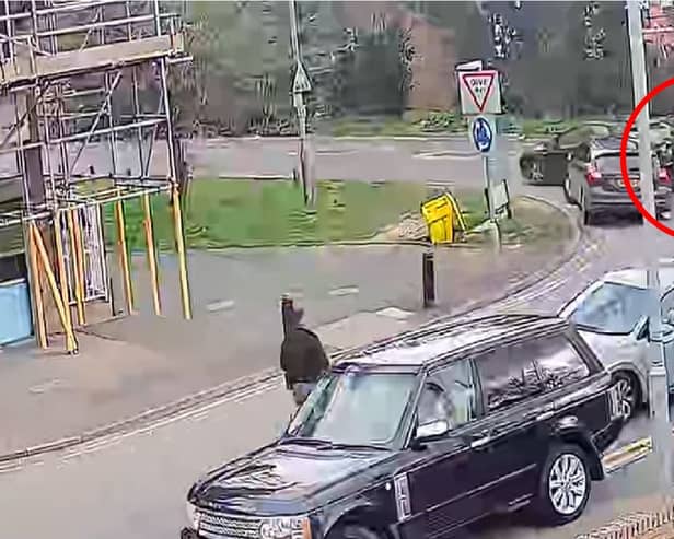 Police officer clings to car roof as suspect speeds off.