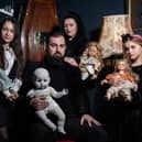 JP Kennedy and Kymmi Jeffery with daughters Snow and Pebble (L-R), known as The Occult Family, holding haunted dolls inside their haunted room.