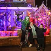 Elliot Smith dressed as a Corn Maze Clown with visitors Penny Unitt and Charlie outside his Halloween house in Stafford.