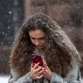 Woman on a smartphone in a snowstorm. Photo: ANATOLII STEPANOV/AFP via Getty Images