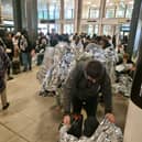 Evacuated Gatwick Airport passengers wrap themselves in foil blankets.