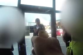 Marius Ciolac is seen standing outside the broken entrance doors of Ascot Drive police station in Derbyshire.