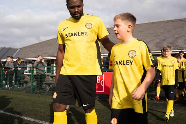 Rugby Borough FC players walk out with junior mascots ahead of the match against Boldmere St Michaels.
