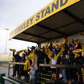 Rugby Borough FC supporters wave their free matchday scarves in the new STANLEY® Stand, built by the club's own players, coaches and volunteers from the trades, on its opening day at the club's Kilsby Lane ground.