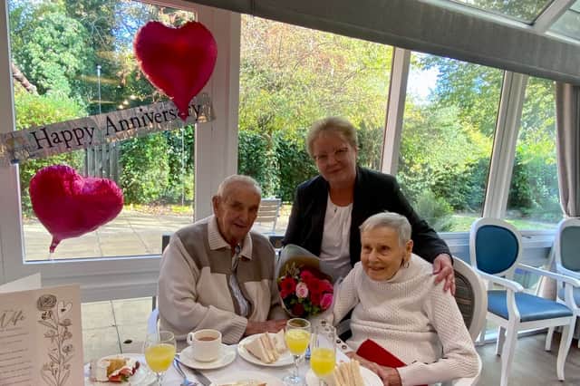General Manager Genoveva Tamasi presents a bouquet to Jenny and Don for their Anniversary