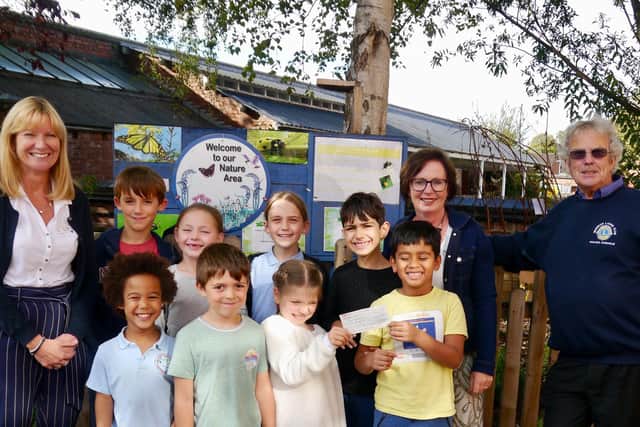 Lion Club Treasurer Neil Chisholm with Head Teacher Julie Miles, teaching assistant Helen Goddard and pupils from Clapham Terrace Primary School. Photo submitted.