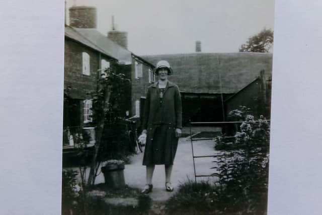 Mrs Emily Goodman, looking very 1930s in her cloche hat, with the thatched 
Temperance Hall in the background and the cottages on her right. This is now the site of Duffy Place, off High Street, Hillmorton.