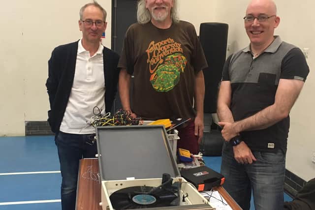 Simon Godwin (centre) and Joel Rowney (right) with a delighted repair cafe customer whose record player was damaged by mice.