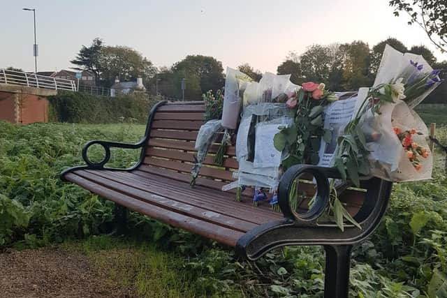 Tributes and flowers have been left on a bench in Portobello Meadow.