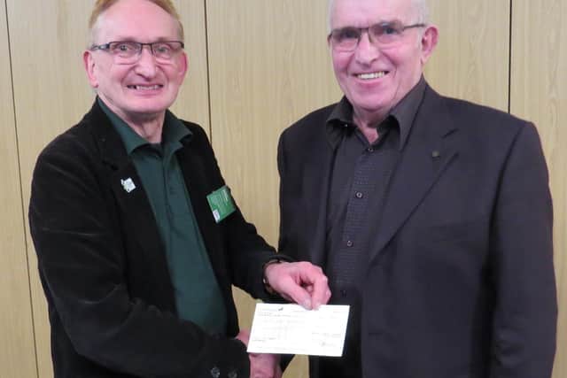 Andy Bower from Warwick District Foodbank receiving a cheque from Warwick Rotary President David Brain. Photo supplied.