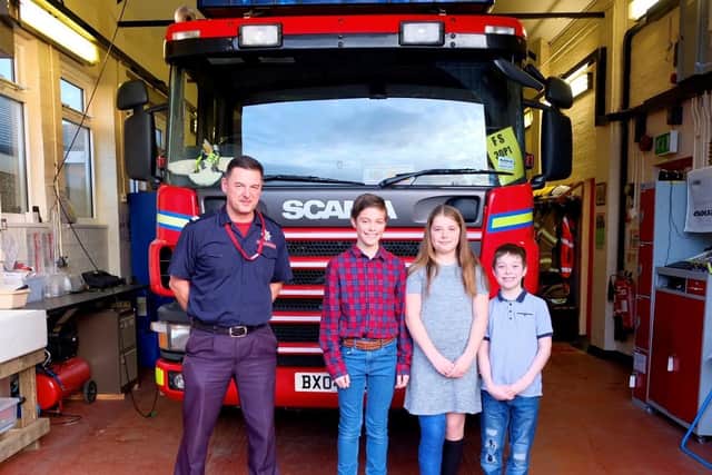 A Warwickshire Fire and Rescue Service official with 13-year-old Oliver, 10-year-old Lucie and 9-year-old Jacob.