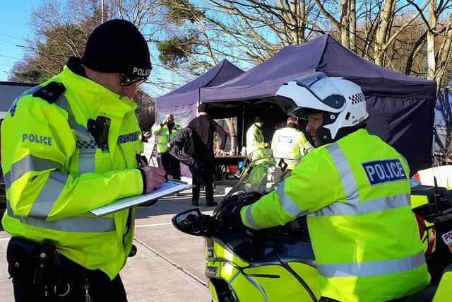 Police motorcyclist passing details to officer during 'safer loads'month.  Photo by Warwickshire Police