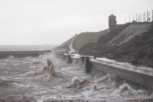The violent waves crashing up against the sea defences.