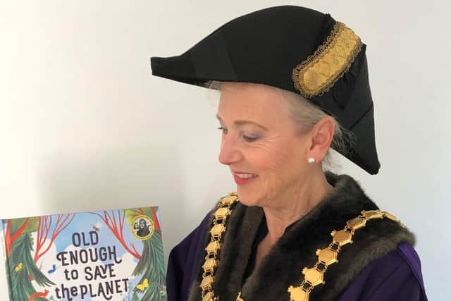Cllr Susan Rasmussen, Mayor of Leamington, with a copy of Loll Kirbys new book Old Enough to Save the Planet which was awarded to the poster competition winners.