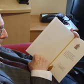 John Campion, also known as Capper to his friends and family, looking at his birthday card from the Queen