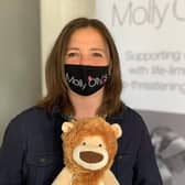 Rachel Ollerenshaw wearing one of the masks and holding Olly the Brave.  Photo supplied