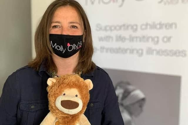 Rachel Ollerenshaw wearing one of the masks and holding Olly the Brave.  Photo supplied