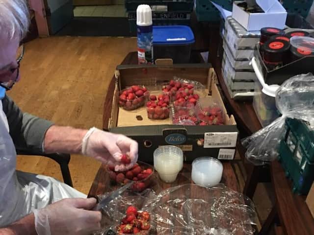 Volunteers at the night shelter preparing the strawberries for the evening meal. Photo supplied