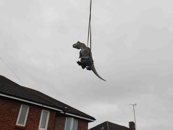 The T-Rex was lifted into the garden by a crane.
