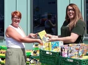 Pictured left to right: Packmores Community Centre’s Local Engagement Officer Debbie Behan is presented with children’s books donated by Leamington Morrisons’ customers, by the supermarket’s Community Champion, Alex Pearson. Photo supplied