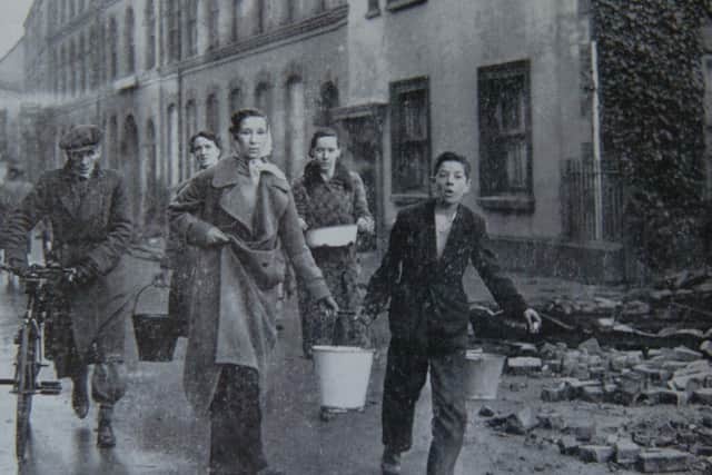 Residents collect buckets of water. The raids often knocked-out telephone lines and utilities.