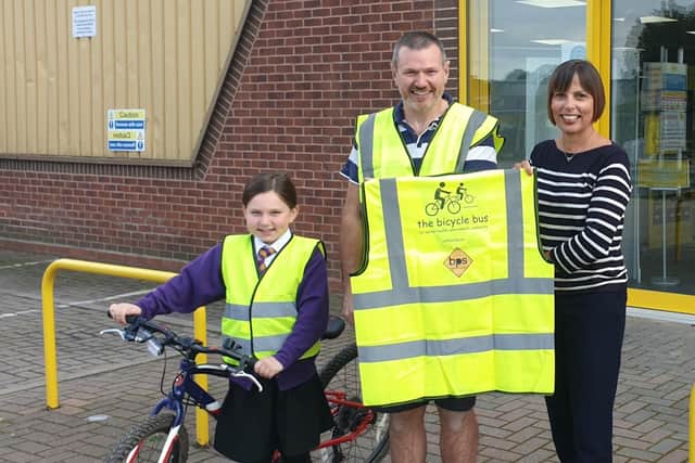 Simon Storey with his daughter Elise and BPS marketing director Emma Dibble presenting hi-viz vests supplied by BPS. Photo supplied