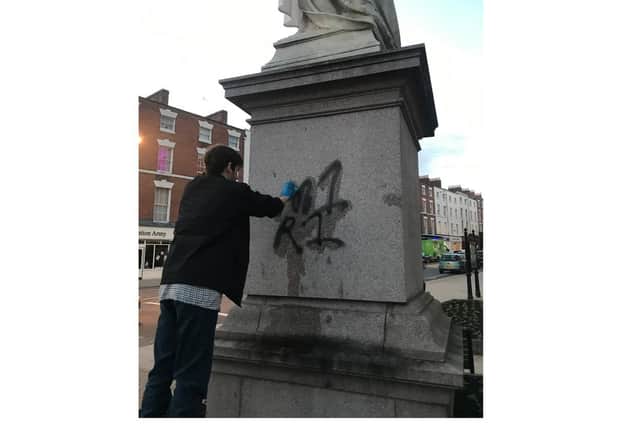 George Mander cleaning the graffiti.