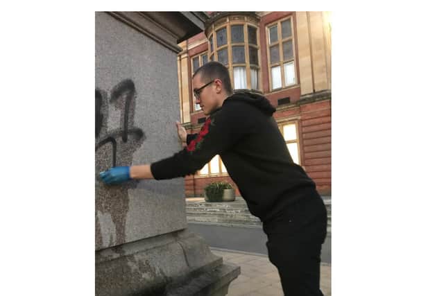 Ethan Liddell cleaning the statue.